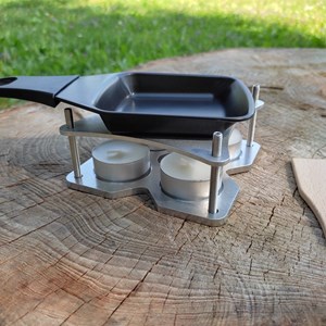 Appareil à raclette à la bougie adapté pour la randonnée et pour la maison.